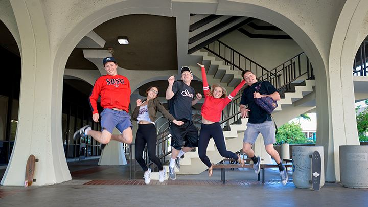 SDSU students jumping for joy outside the library