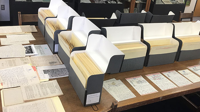 Boxes and stacks of archival materials on a table