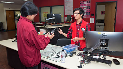 Student employee checking out equipment to a patron