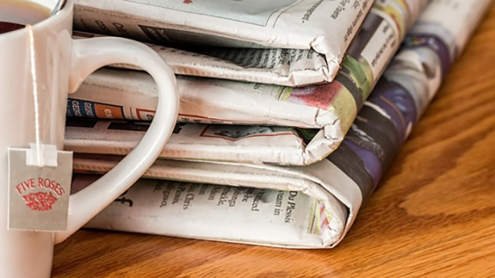 Stack of newspapers and a mug of tea