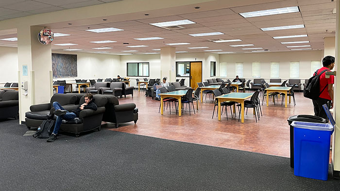 tempLounge seating and individual study tables in the SDSU Library After Hours Study Area with students working.